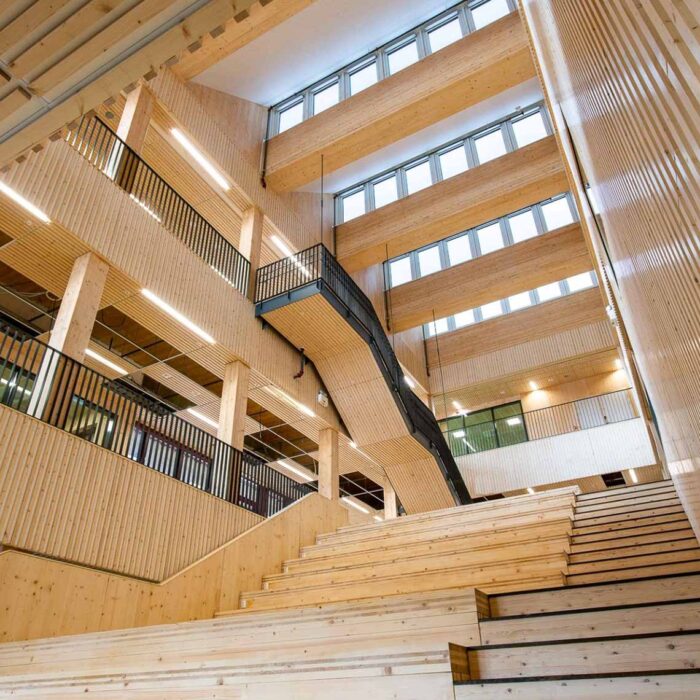 Helle und moderne Schularchitektur in Lillestrøm mit Holzbauweise, großen offenen Bereichen und Treppen. Errichtet mit KNAPP-Verbindern Ricon S und Megant. Fotografie: Nils Petter.
