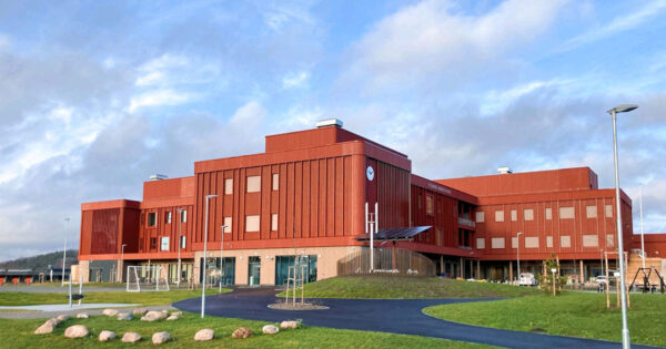 Moderne Schule in Lillestrøm mit roter Holzfassade, gebaut mit KNAPP-Produkten Ricon S und Megant, fotografiert von Nils Petter.